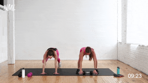 two women performing a push up pop squat hold and dumbbell press out as part of a cardio and core workout at home