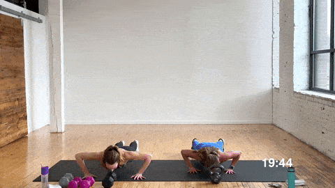 two women performing a push up and reach in a total body workout at home