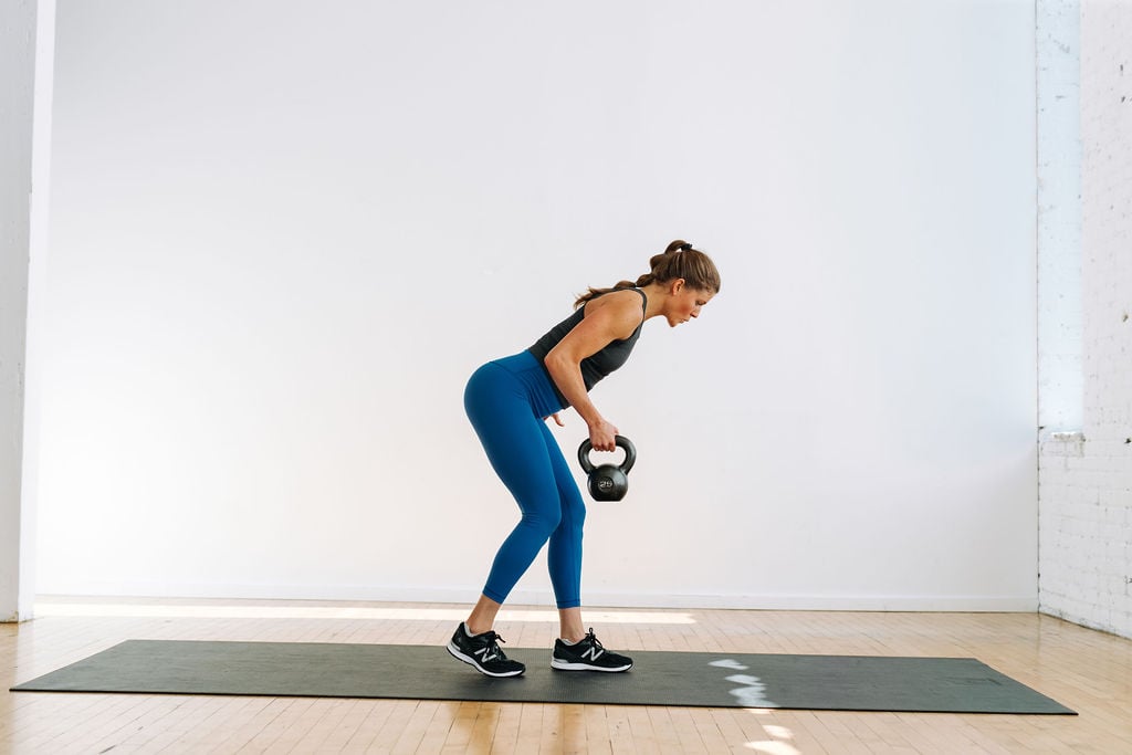 woman performing a single arm row with kettlebell