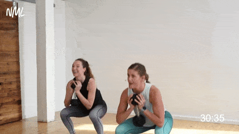 two women performing a goblet squat in a strength training workout at home 