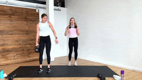 two women performing a lateral lunge and narrow squat in a total body kettlebell workout
