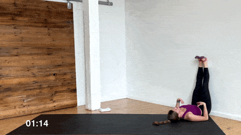 woman performing a legs up the wall stretch to relieve tired legs