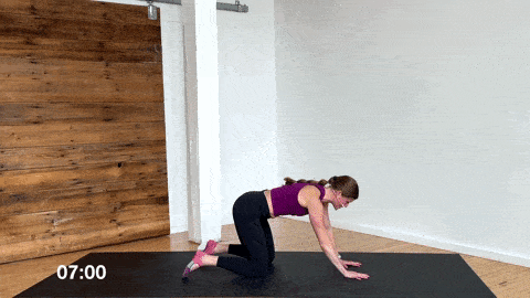 woman performing a puppy dog yoga stretch