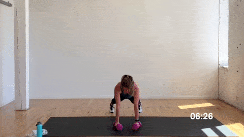 woman performing a burpee with push up and bicep curl in a superset workout