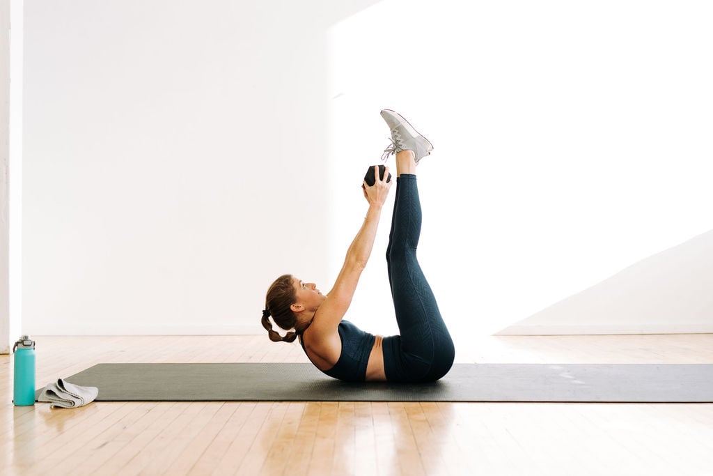 woman performing a weighted crunch in a cardio abs workout