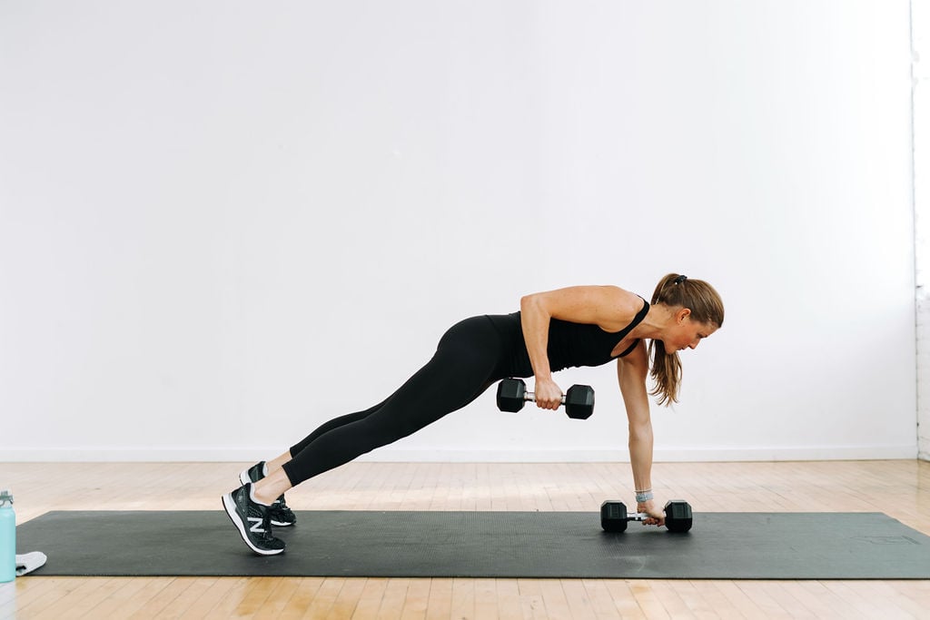 woman performing a plank and single arm row in a back and bicep workout