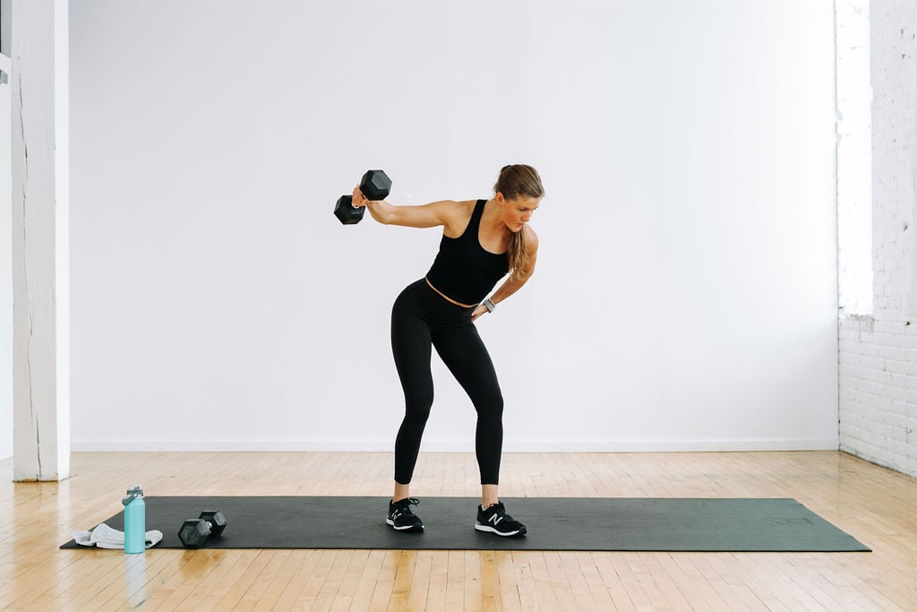 woman performing a dumbbell back fly in a Back and Biceps Workout 