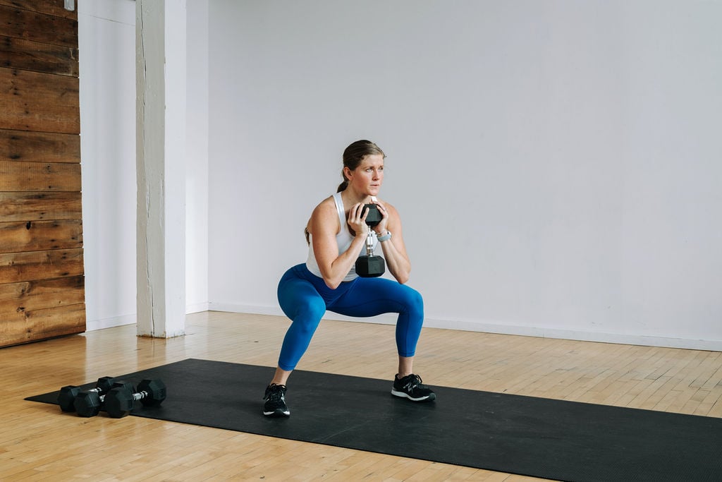 Woman performing a goblet squat hold in a Leg and Glute Workout