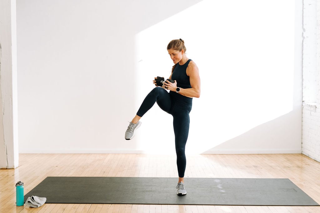 woman performing a standing oblique crunch with a dumbbell | best ab exercises with weights