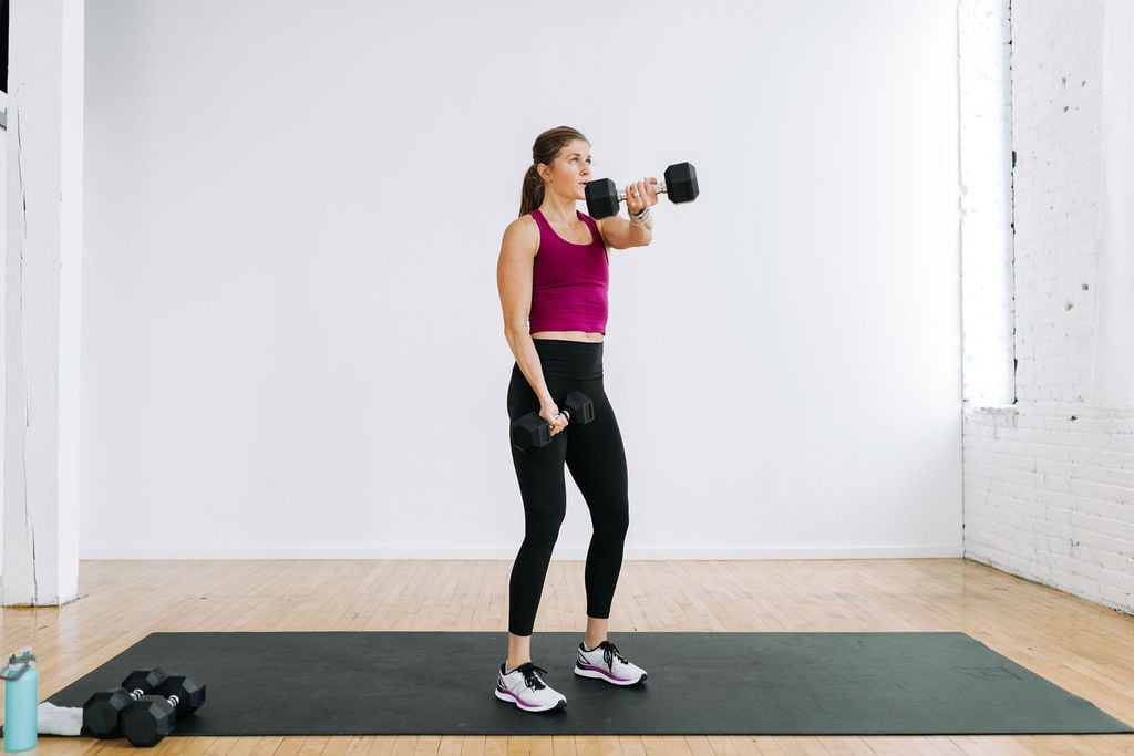 woman performing a cross body chest fly with dumbbells in a Legs and Chest Workout