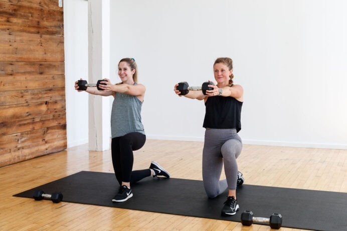 Postpartum workout | two women performing a dumbbell raise while kneeling.