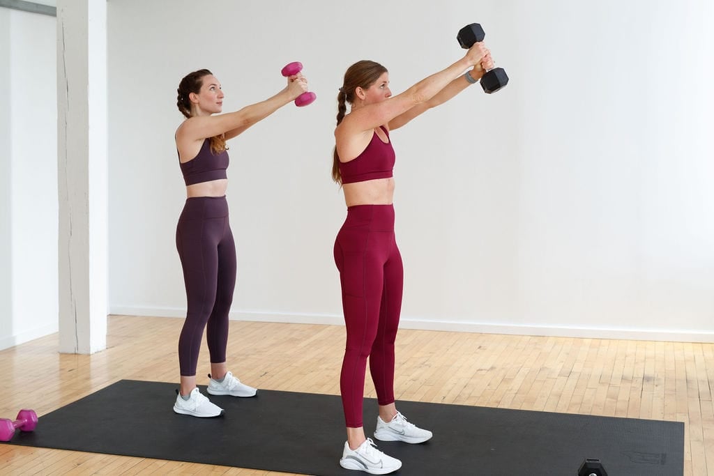 full body strength workout | Two women doing a 45 degree press out with 15 pound dumbbell. 