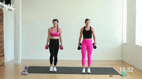 two women performing a reverse lunge and hammer curl with rotational press in a strength and conditioning workout