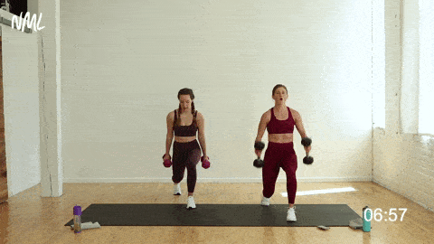 two women performing an isometric lunge hold hammer curl in a strength workout at home