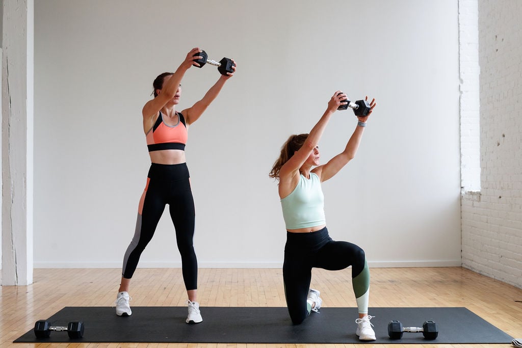 two women performing a cross body dumbbell chop in a full body HIIT workout at home