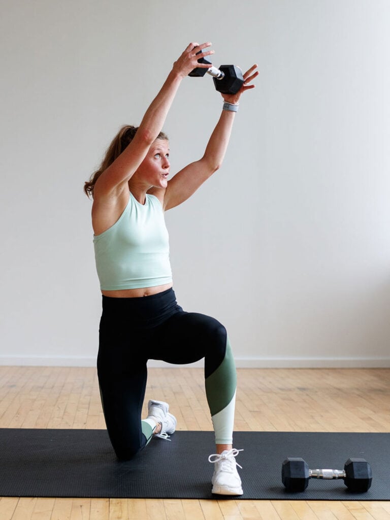 Woman performing a crossbody dumbbell chop as part of 5 Moves to Blast Your Abs with a Dumbbell