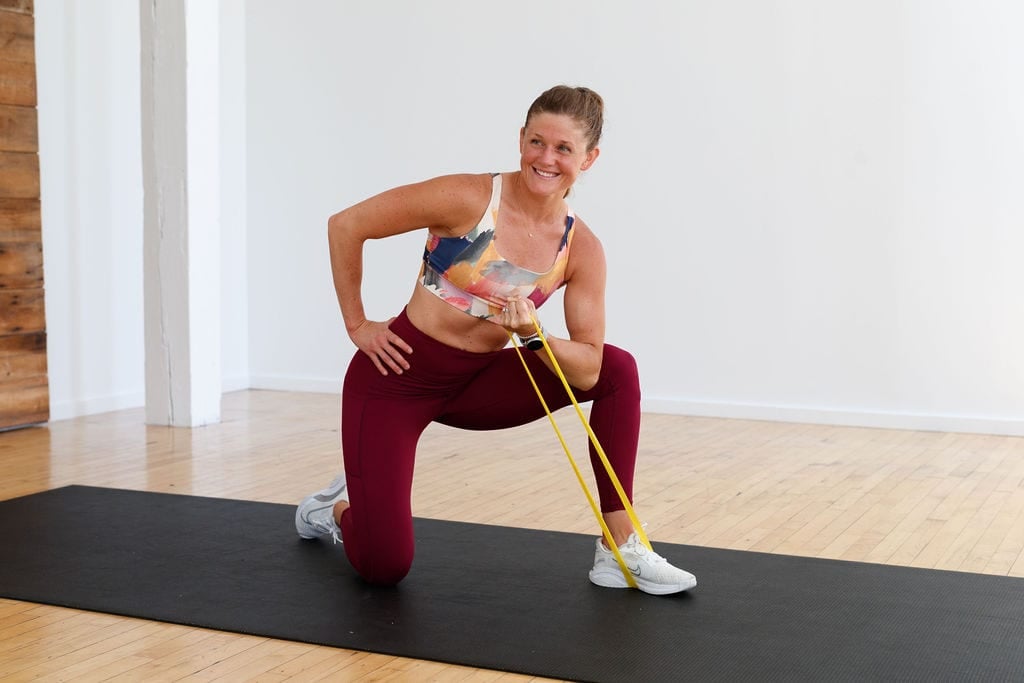 woman performing a concentration bicep curl in a resistance band arm workout for women