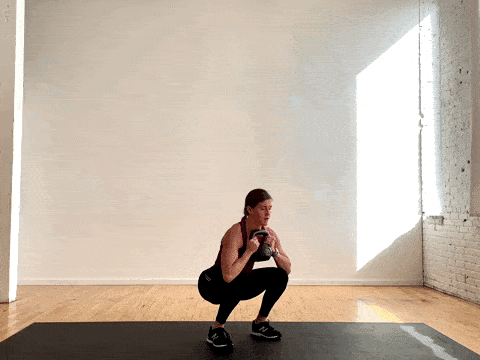 woman performing a kettlebell squat thruster as part of the best kettlebell exercises for women