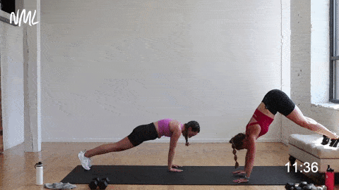 two women performing decline plank walk outs or decline plank pikes