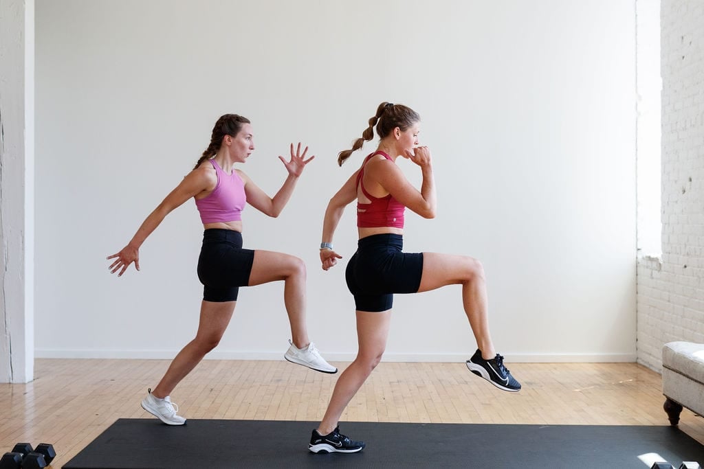 two women performing a front lunge with knee drive in an athletic HIIT workout at home