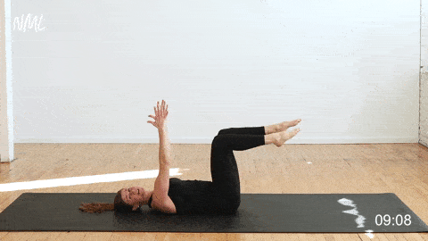 woman performing lying leg extensions to target the lower ab muscles