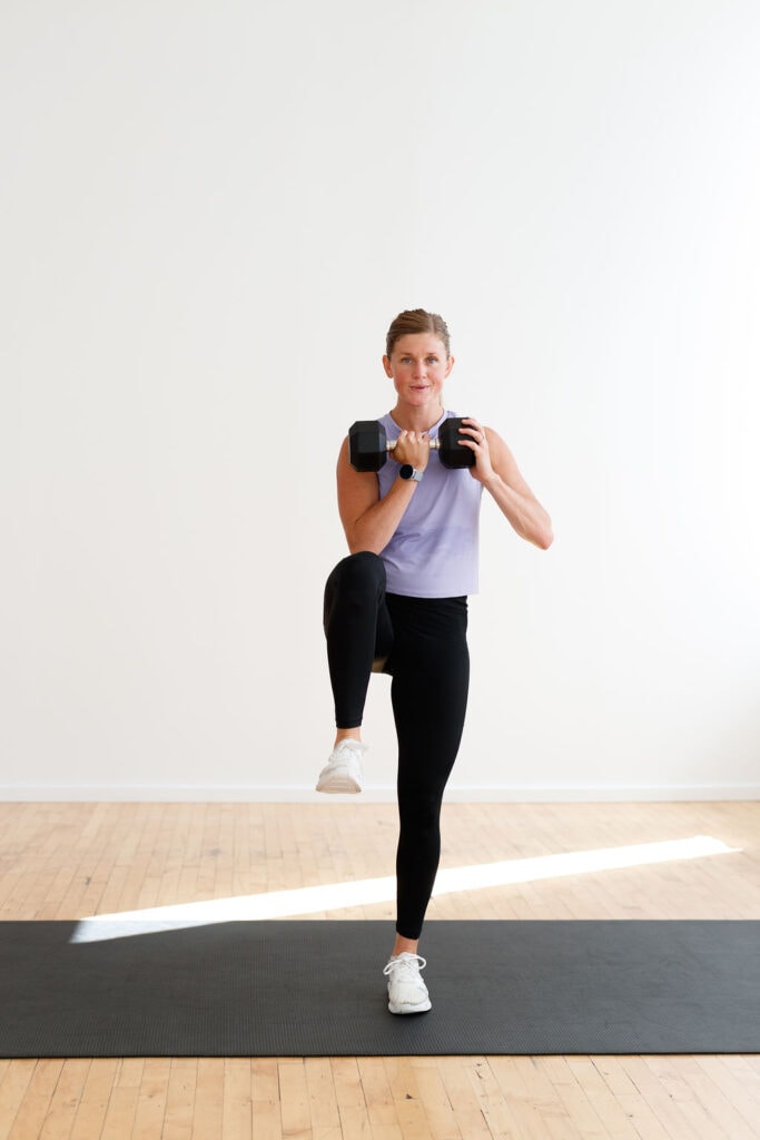 pregnant woman performing a balance clean with a dumbbell in a first trimester HIIT workout