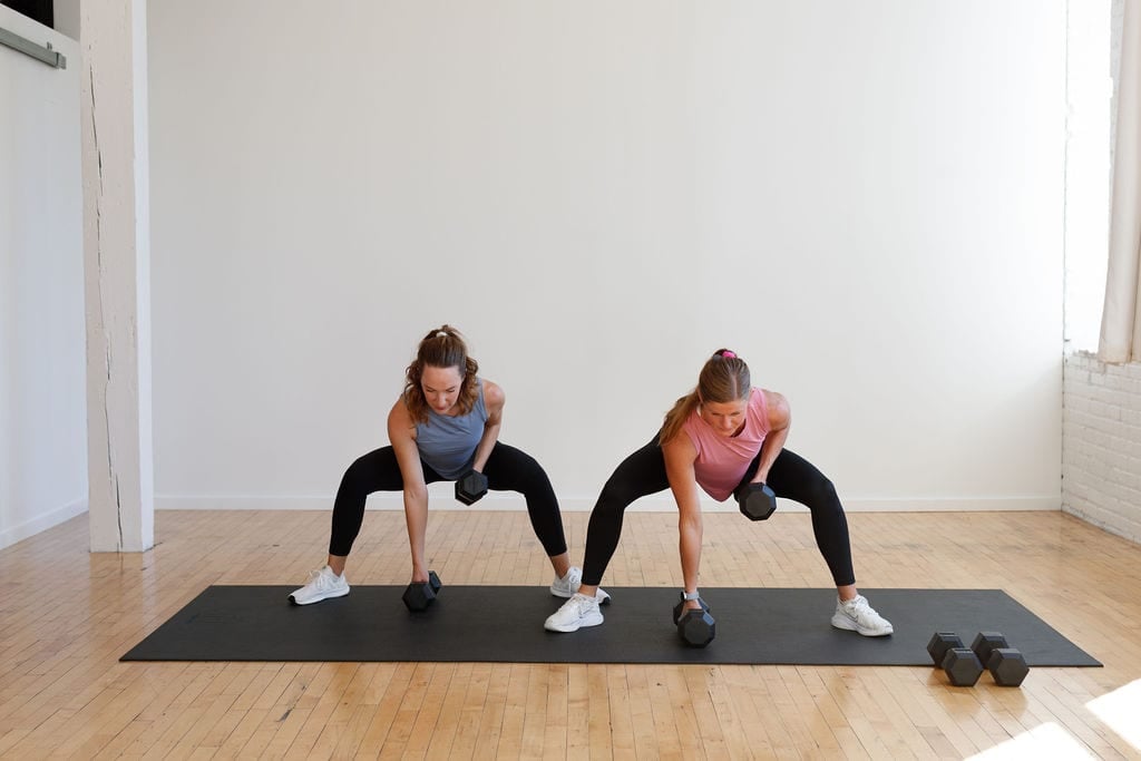 two women, one pregnant, performing a wide squat and back row demonstrating the benefits of exercising during pregnancy