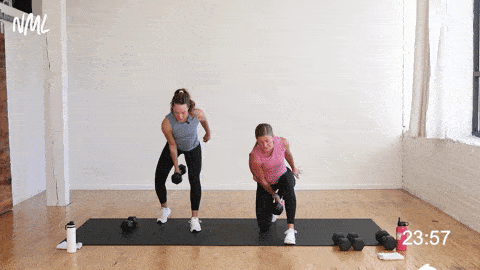 two women, one pregnant, performing a hinge swing and single arm press as part of a pregnancy workout at home