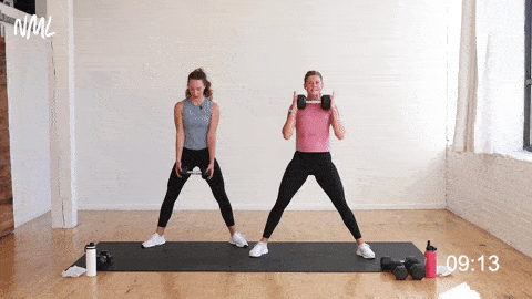 two women, one pregnant, performing a sumo deadlift and back row and sumo squat as part of first trimester exercises