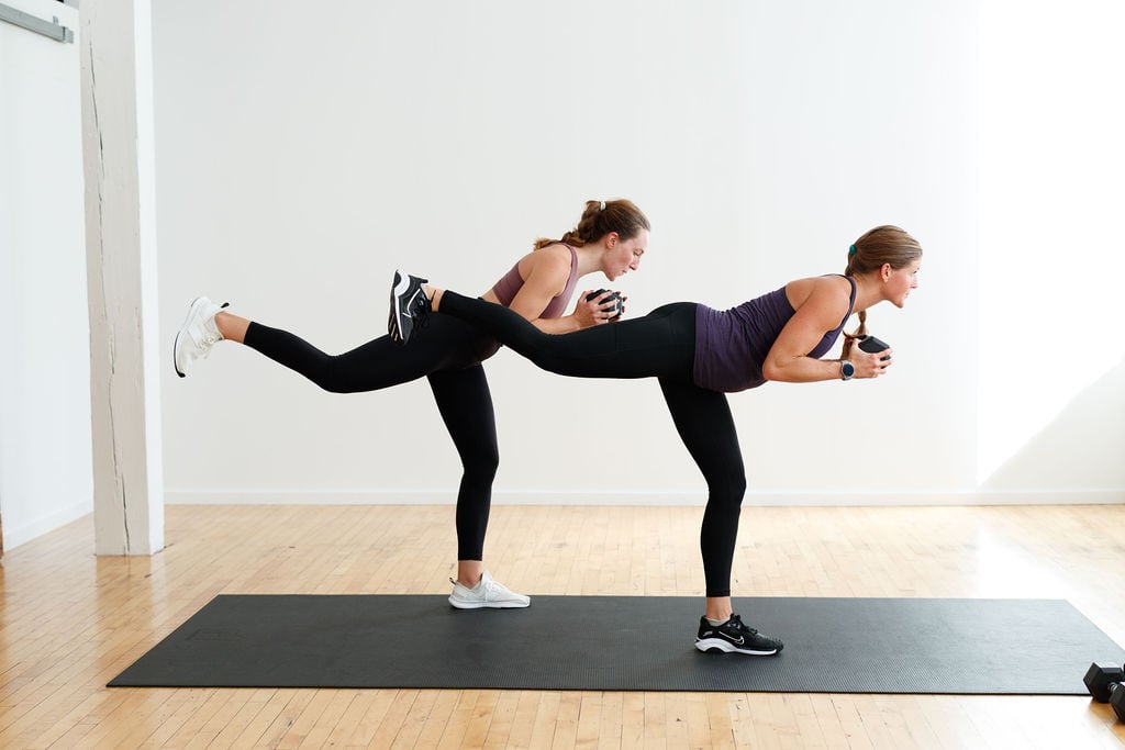 two women performing a rear kick in kickboxing drills at home 