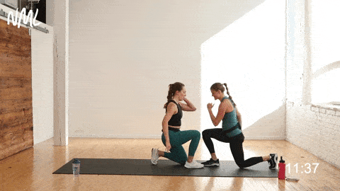 two women performing alternating lunges or pendulum lunges in a partner workout