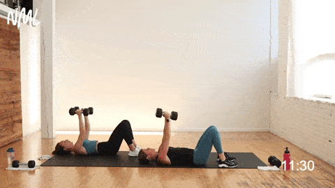 two women performing a dumbbell chest fly as an arms exercise with weights