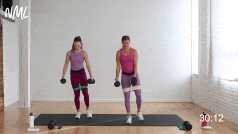 two women performing a curtsy lunge and leg lift in a leg and glute workout
