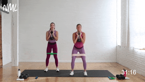 two women performing a goblet squat with resistance band in a butt and thigh workout