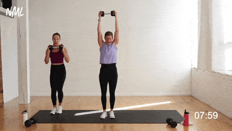 two women performing a lateral squat thruster as a prenatal cardio exercise at home