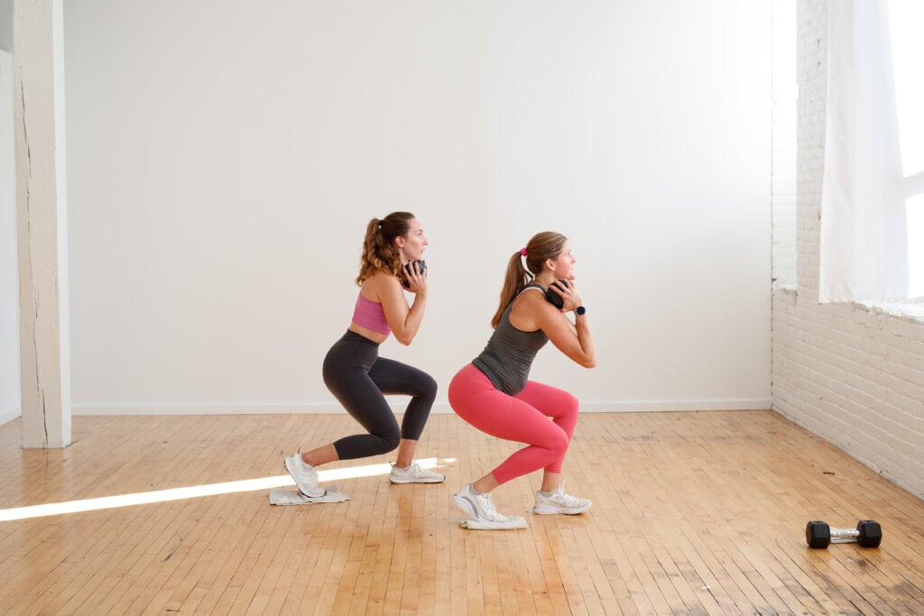 two women performing a lunge exercise with towel slide in a low impact workout