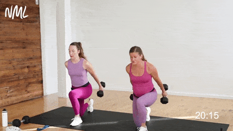 two women performing lunge swings in a glute workout at home with dumbbells