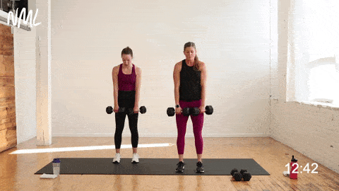 two women performing double leg deadlifts in a leg superset workout