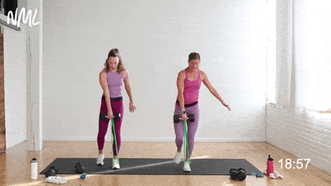 two women performing a single leg deadlift with dumbbells and mini band