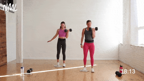 two women performing a single sided lateral lunge and bicep curl