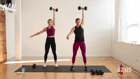 two women performing a single arm dumbbell snatch in a leg superset workout