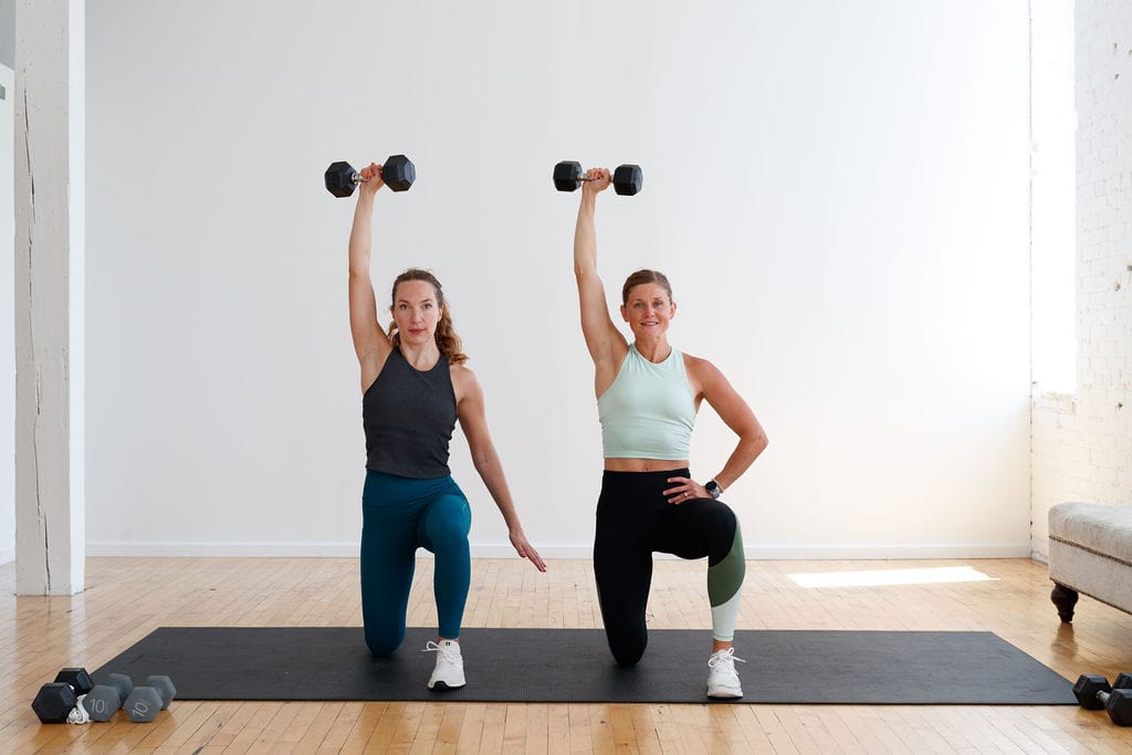 two women performing a half kneeling Arnold Press | dumbbell shoulder exercise