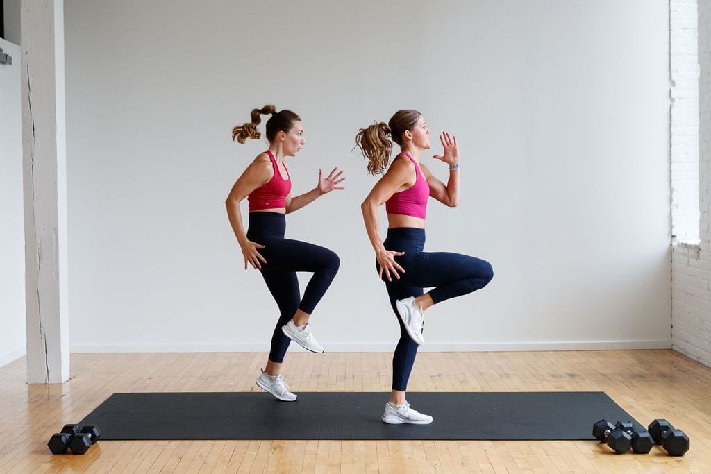 two women performing high knees in a HIIT workout at home for the abs and obliques