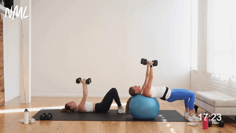two women performing a dumbbell chest fly in a chest and arm workout with dumbbells