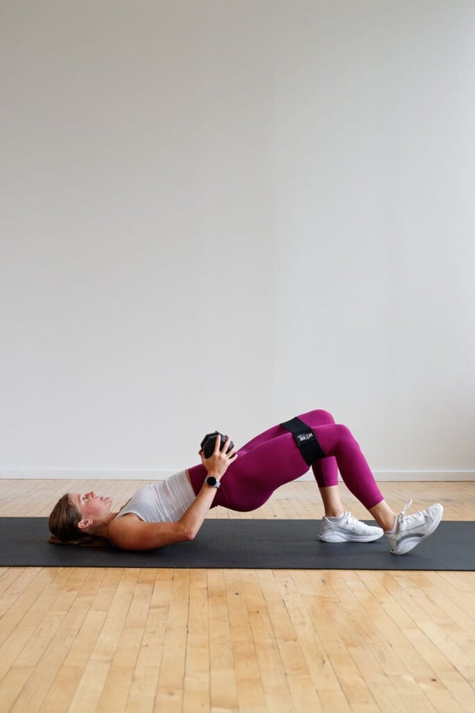 woman performing a glute bridge with resistance bands