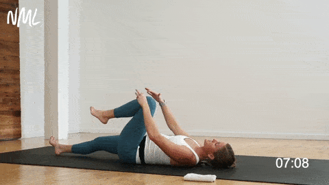 woman performing a lying hip flexor stretch for tight hips