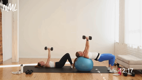 two women performing a narrow chest press and skull crushers in an upper body dumbbell workout