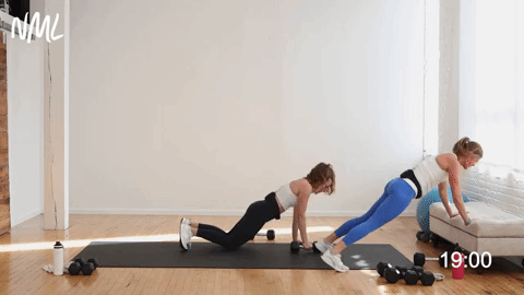 two women performing a push up burpee and two single arm rows in an upper body workout for women