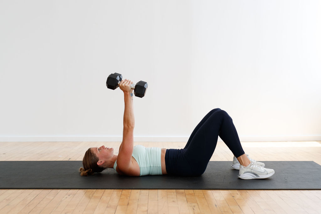 woman performing skull crushers as part of an upper body hiit workout