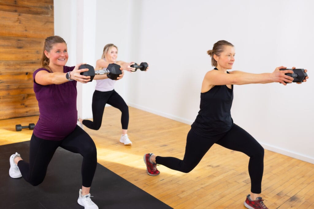 3 women holding a dumbbell pressed out away from their chests (hiit circuit)